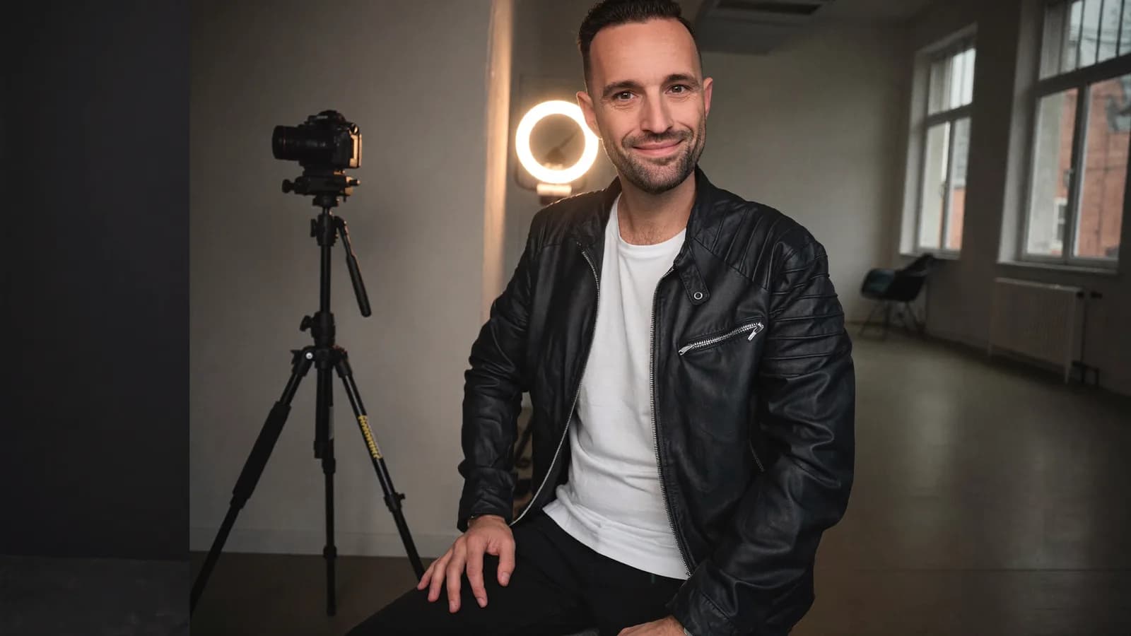 Torsten Schiefen in a leather jacket in front of camera and ring light in a loft studio