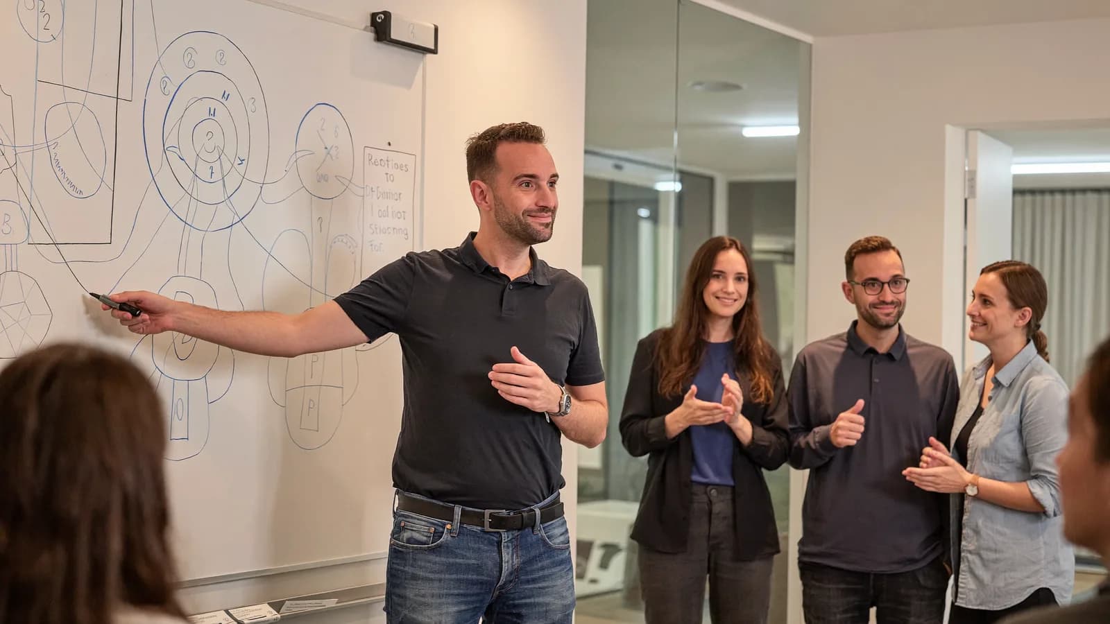 Torsten Schiefen presenting at a whiteboard in front of a small team