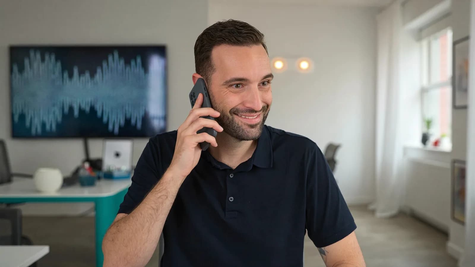 Torsten Schiefen on the phone smiling, a soundwave visual in the background